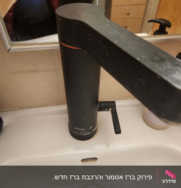 ברז שחור עם ידית על כיור לבן